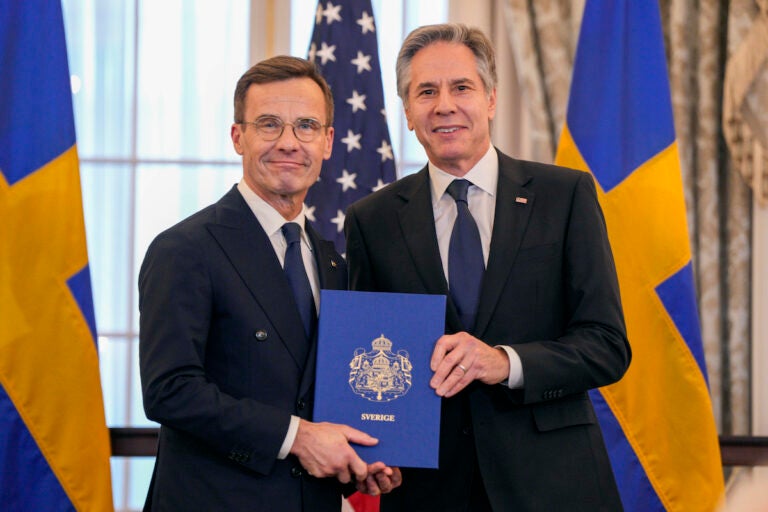 Secretary of State Antony Blinken (right) poses for a photo with Swedish Prime Minister Ulf Kristersson holding Sweden's NATO Instruments of Accession in the Benjamin Franklin Room at the State Department, Thursday, March 7, 2024, in Washington.
