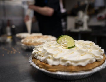 A freshly decorated Key Lime pie rests on a counter in a busy bakery kitchen at Michele's Pies, Wednesday, March 13, 2024, in Norwalk, Conn.