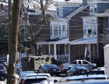 Police surround a home in Trenton, N.J., Saturday