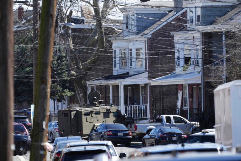 Police surround a home in Trenton, N.J., Saturday