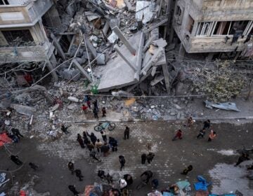 Palestinians inspect the damage of residential buildings