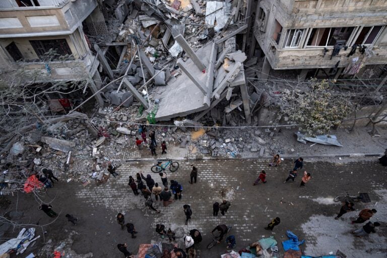 Palestinians inspect the damage of residential buildings