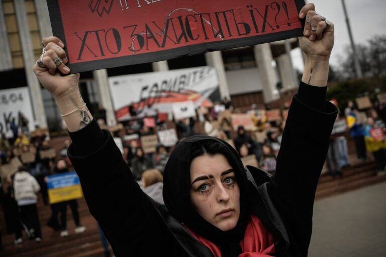 A woman holds a sign during a protest in Kyiv, Ukraine.