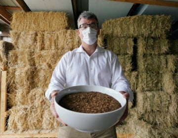 Micah Truman holding a container filled with soil