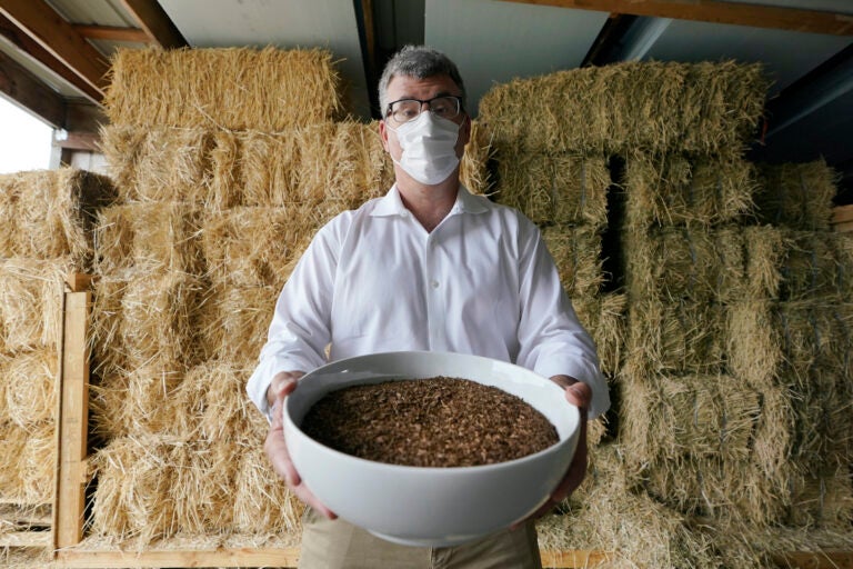 Micah Truman holding a container filled with soil