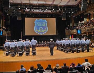 New Philly Police officers take the oath of office as they stand on a stage.