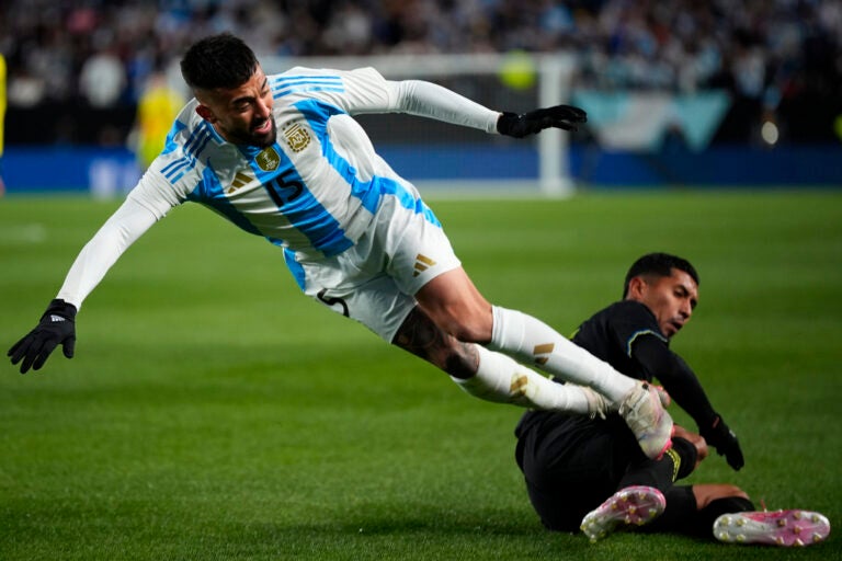 Argentina's Nicolas Gonzalez, left, collides with El Salvador's Melvin Cruz during the first half of a friendly soccer match