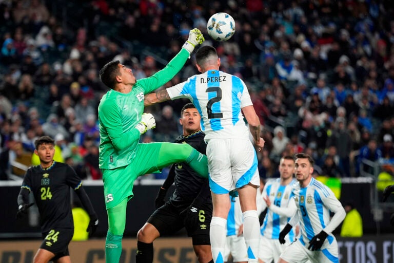 El Salvador's Mario Gonzales, left, punches the ball away from Argentina's Nehuen Perez during the first half of a friendly soccer match