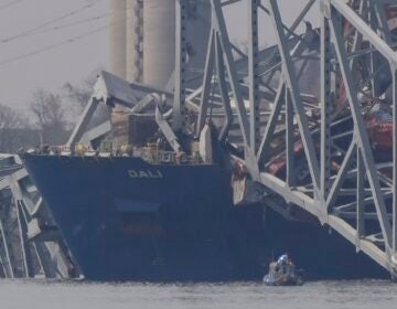 A container rests against wreckage of the Francis Scott Key Bridge