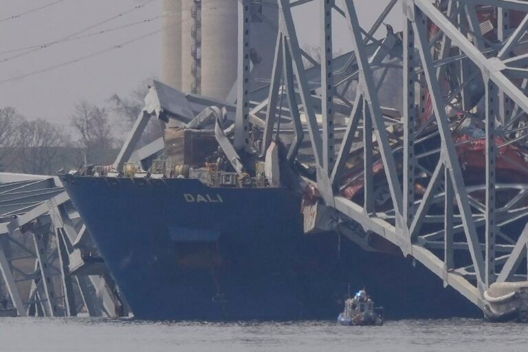 A container rests against wreckage of the Francis Scott Key Bridge
