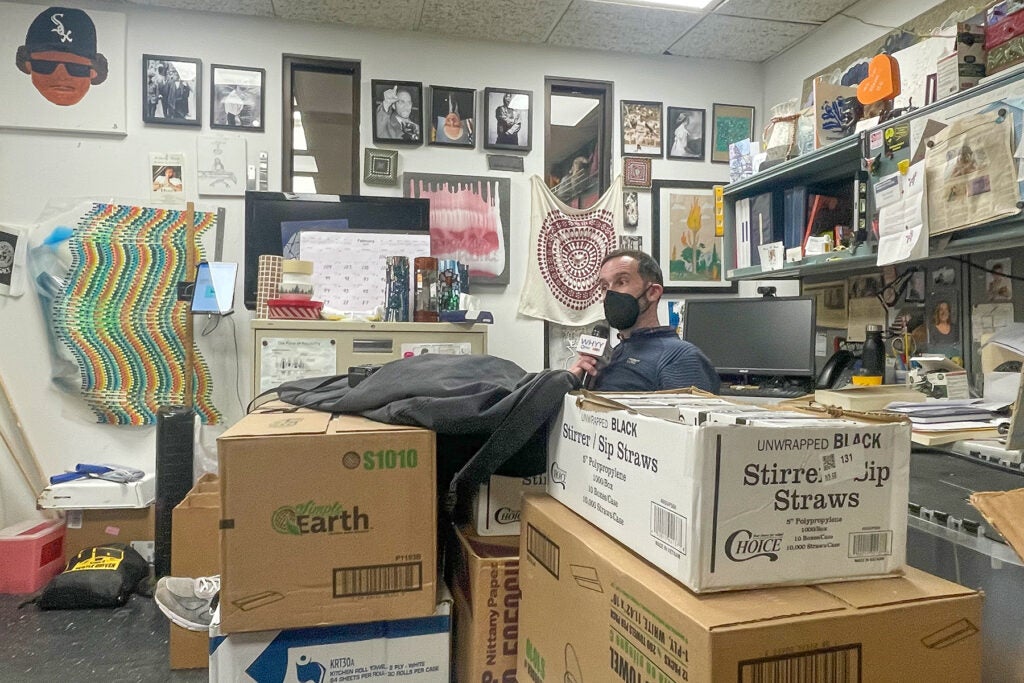 Michael Kalmbach sitting in his office with lots of boxes piled up