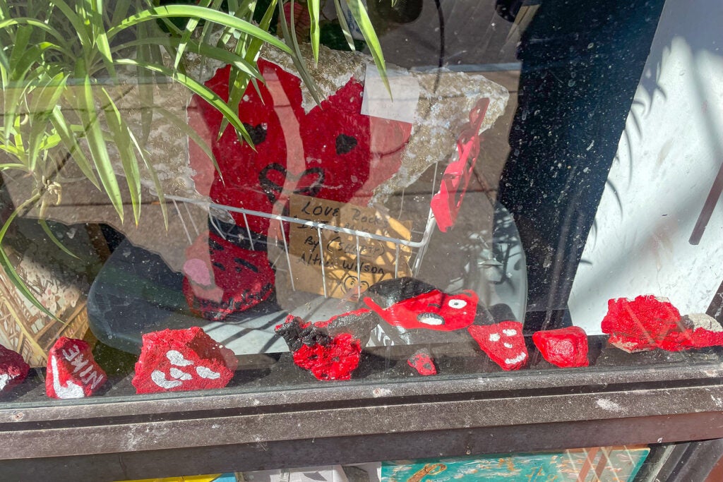 Rocks painted red sit inside a windowsill