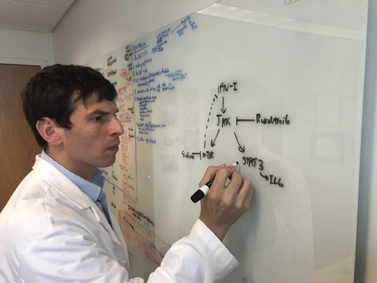 David Fajgenbaum writes on a white board