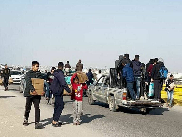 In this image grab from an AFPTV video, people carry food parcels that were airdropped March 2 from U.S. aircraft above a beach in the Gaza Strip. President Biden is set to announce the setting up of another avenue for aid to Gaza.