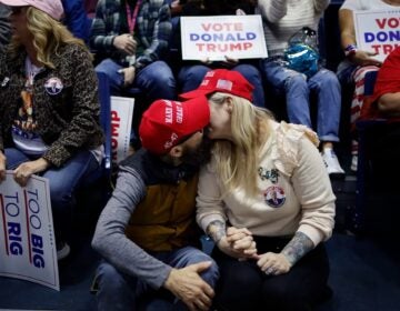 A couple kisses while waiting for the start of a campaign rally with former President Donald Trump on March 9 in Rome, Ga.