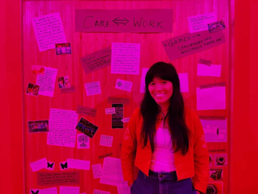 Artist Risa Puno inside the bahay kubo, in her installation