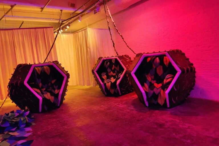 Relaxation pods in pink light at the installation at the Fabric Workshop