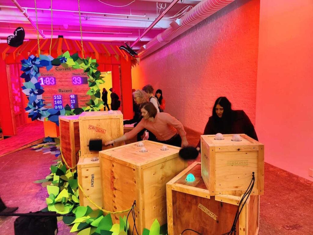 Players play a game of Whac-a-Mole at an art installation