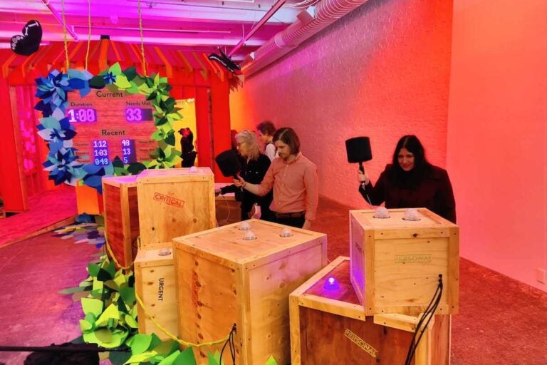 Players play a game of Whac-a-Mole at an art installation