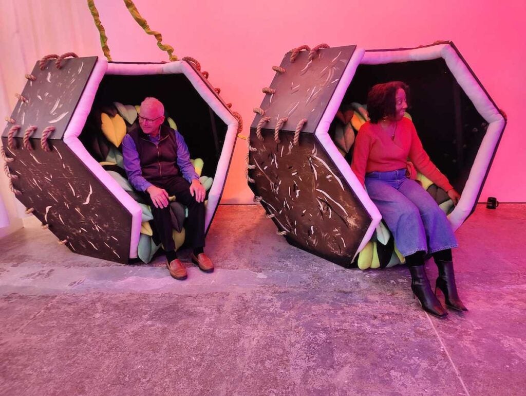 Visitors sit in relaxation pods at an art installation