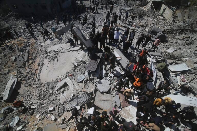Palestinians look at a residential building destroyed in an Israeli strike in Rafah, Gaza Strip, Tuesday, March 20, 2024.