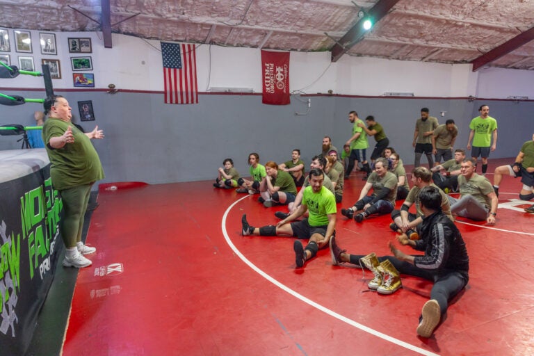 Pro-wrestler and coach Melissa Sampson (left) runs down the plan for Tuesday night training at the Monster Factory in Paulsboro, N.J. (Kimberly Paynter/WHYY)