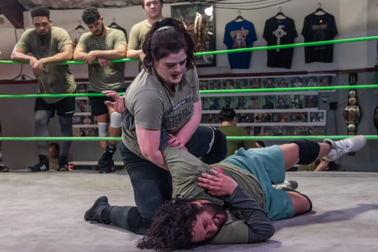 Wrestler Christian Darling smiles while upside down in the ring at the Monster Factory in Paulsboro, N.J. (Kimberly Paynter/WHYY)