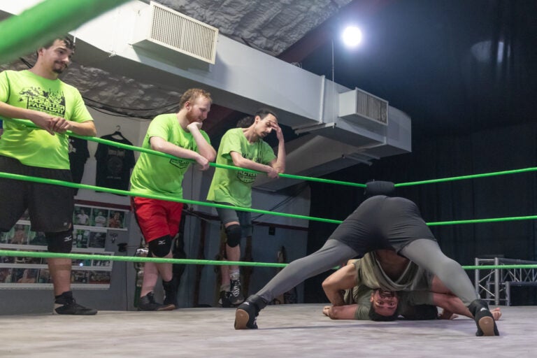 Wrestler Christian Darling smiles while upside down in the ring at the Monster Factory in Paulsboro, N.J. (Kimberly Paynter/WHYY)