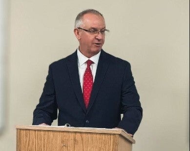 Rob Coupe speaking at a podium