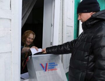 A woman casts a ballot in Russia