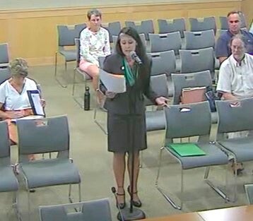 Zoe Patchell speaking into a microphone at a hearing