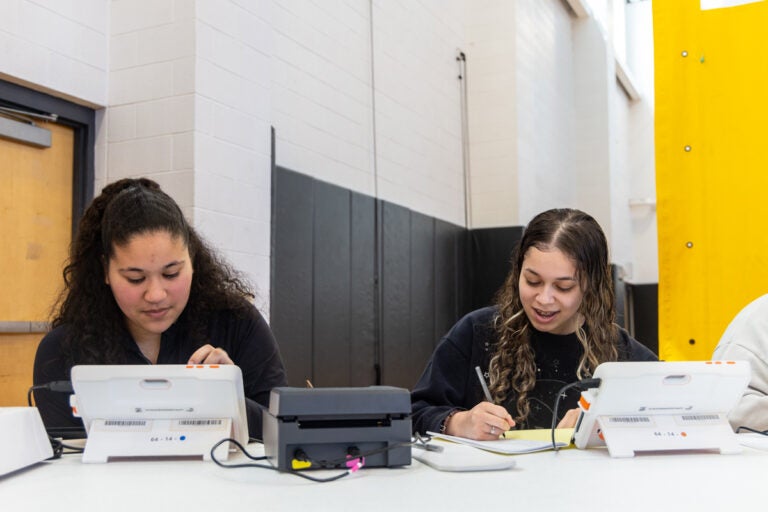 Poll workers Maria Moreira, Lincoln High School class of ’23 (left) and senior Victorya Santos at work in the school’s gymnasium