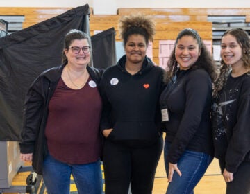 (From left) Sarah Caswell, a special education and science teacher at Lincoln High School, with young poll workers, junior Didianna Victorino, alum Maria Moreira and senior Victorya Santos, in the school’s gymnasium on primary Election Day April 23, 2024.