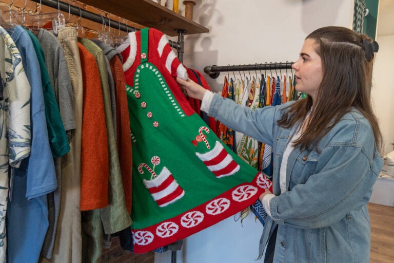 ReUp Fashion store owner Tara Martinak with a holiday find for sale at her Haddon Township, N.J. (Kimberly Paynter/WHYY)