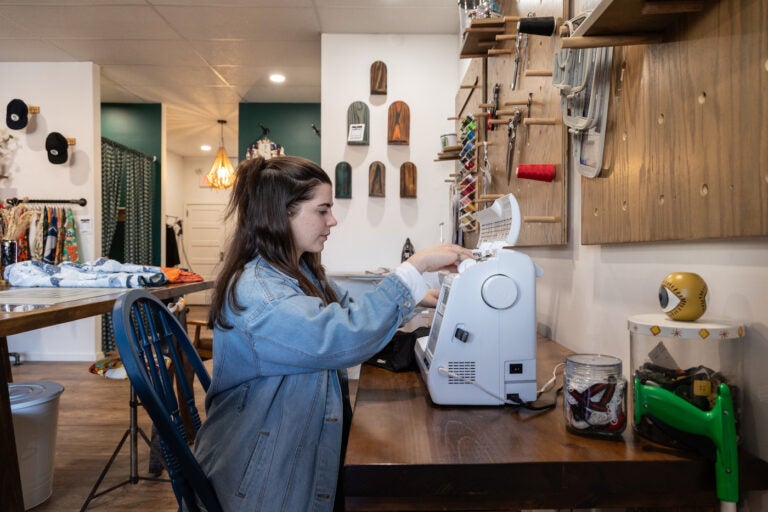 ReUp Fashion store owner Tara Martinak at her sewing machine in her store in Haddon Township, N.J. (Kimberly Paynter/WHYY)