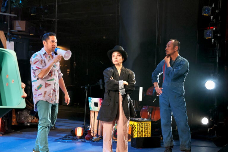 Justin Jain (left) directs Bi Jean Ngo (center) and Makoto Hirano (right) in the Wilma Theater production of ''The Good Person of Setzuan.'' (Emma Lee/WHYY)