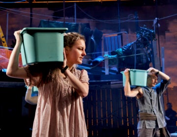 Recycled plastic bins become props and percussion instruments for the cast of ''The Good Person of Setzuan'' at Wilma Theater. (Emma Lee/WHYY)