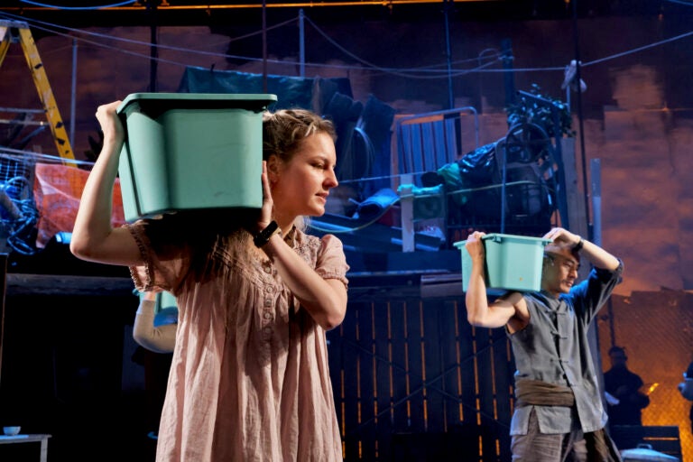 Recycled plastic bins become props and percussion instruments for the cast of ''The Good Person of Setzuan'' at Wilma Theater. (Emma Lee/WHYY)