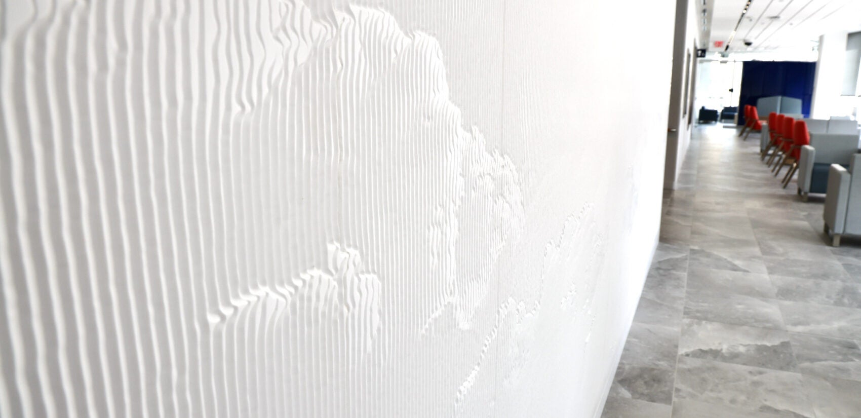 a white wall textured with long, wavy lines and grooves