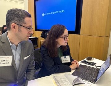 Pro-bono attorneys Jeff Rosenthal, partner at Blank Rome and JPMorgan Chase's Mary McCullough work together on a pardon in West Philadelphia. (Kristen Mosbrucker-Garza/WHYY)