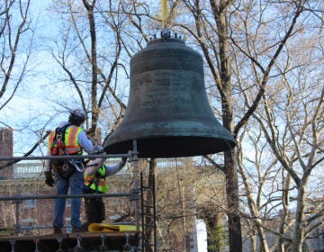 An engineering team placed the Bicentennial Bell, which had been in storage since 2013, in its new home in the Bicentennial Bell Garden on 3rd and Walnut streets on April 6, 2024. (Emily Neil/WHYY)