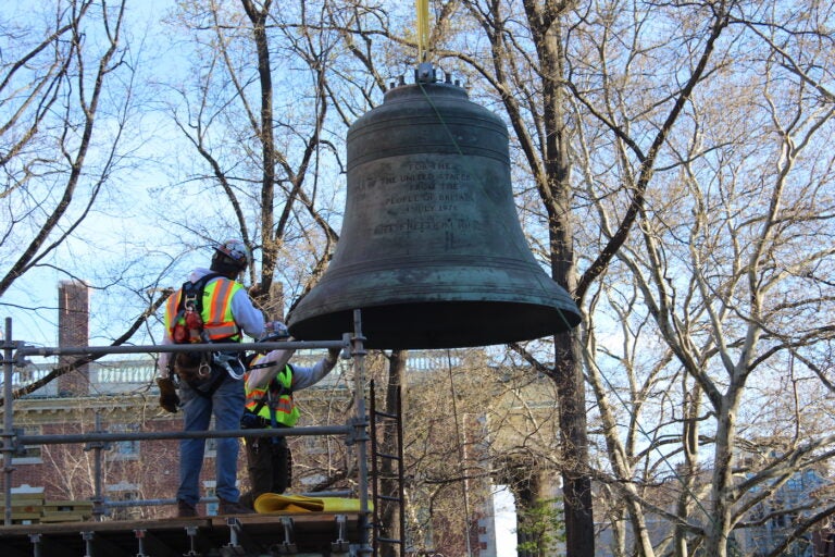 An engineering team placed the Bicentennial Bell, which had been in storage since 2013, in its new home in the Bicentennial Bell Garden on 3rd and Walnut streets on April 6, 2024. (Emily Neil/WHYY)