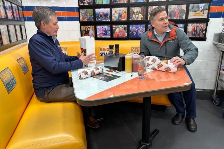 National Republican Senate Committee Chairman Steve Daines of Montana and Republican Senate candidate David McCormick sit down to enjoy Philly cheesesteaks at Geno’s Steaks in South Philly. (Carmen Russell-Sluchansky/WHYY)