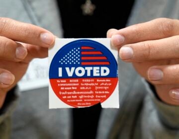 A election volunteer offers voters an 