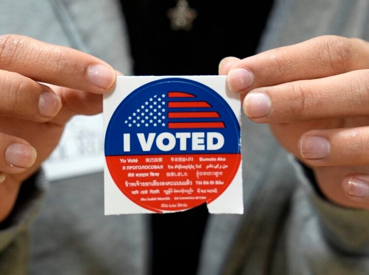 A election volunteer offers voters an 