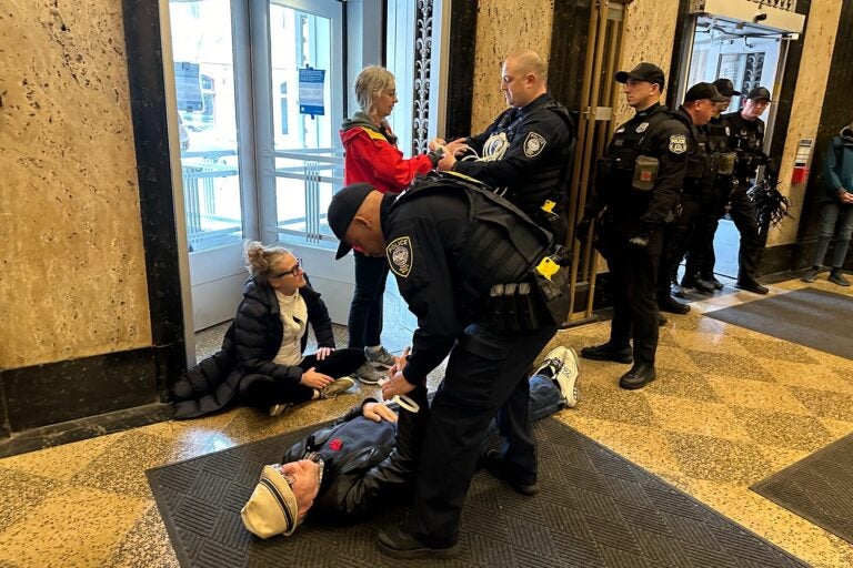 Police arrest activists for blocking the entrances of the U.S. Customs House in Old City