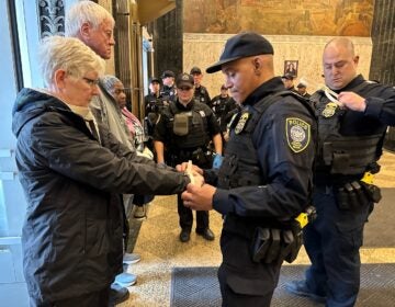 Police arrest activists for blocking the entrances of the U.S. Customs House in Old City