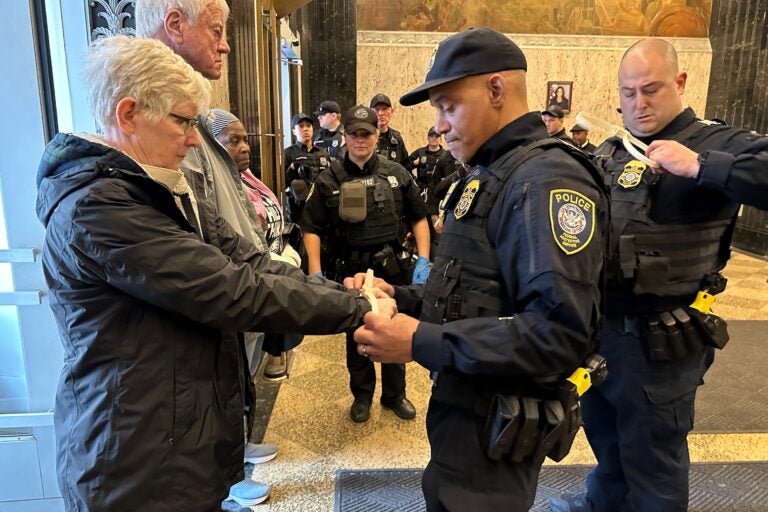 Police arrest activists for blocking the entrances of the U.S. Customs House in Old City