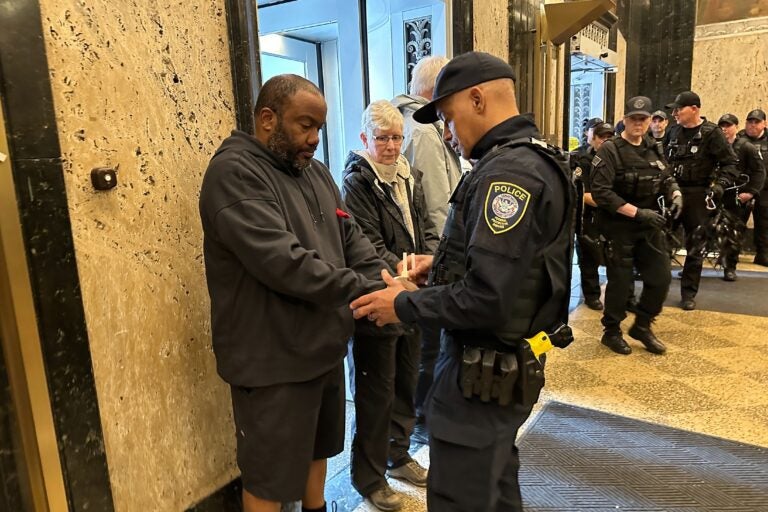 Police arrest activists for blocking the entrances of the U.S. Customs House in Old City