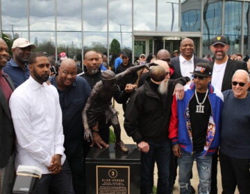 Allen Iverson and his former teamates posing next to the statue